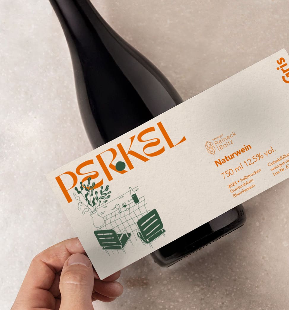 Das Foto Zeigt eine Weinflasche mit einer Hand, die ein Weinetikett mit der Aufschrift Perkel Naturwein versehen ist.